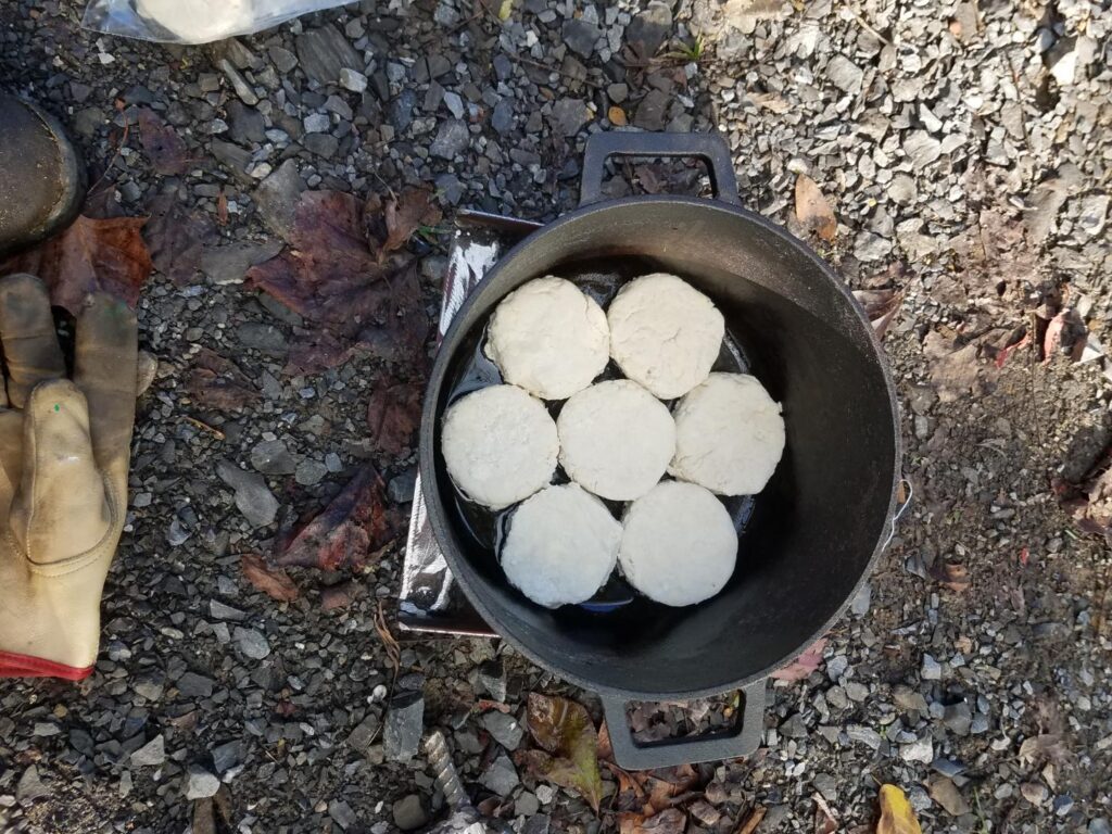Eight raw biscuits arranged in the oiled dutch oven